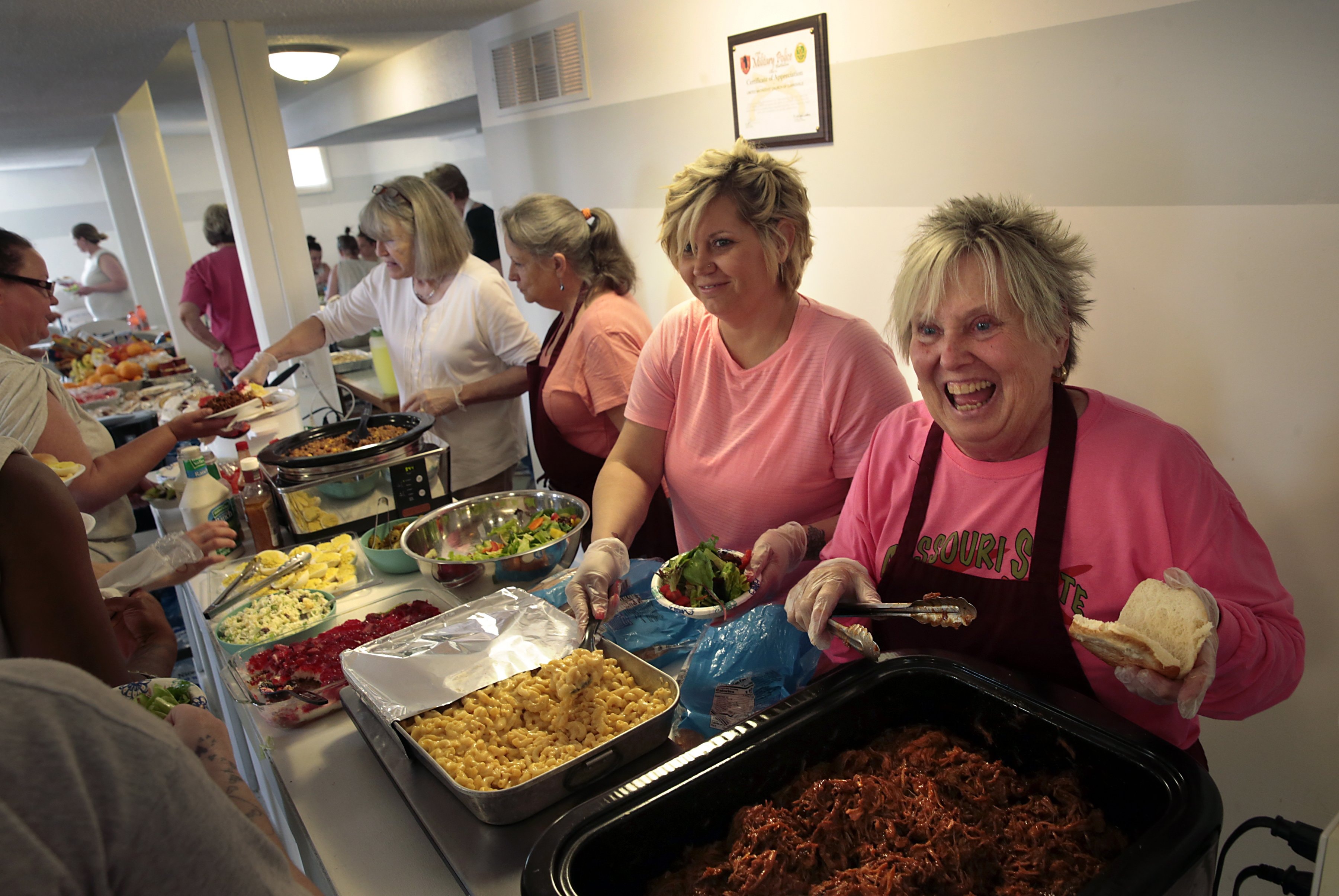 Linda Blakey (right) joins Jennifer McCormick, Janie Busch and Erin Garrison in the “flood kitchen” at Clarksville United Methodist Church in Missouri as they feed inmates from the women's prison in Vandalia and others who served as volunteers to fill sandbags and protect the town from flooding. Photo by Robert Cohen/Post Dispatch/Polaris. 