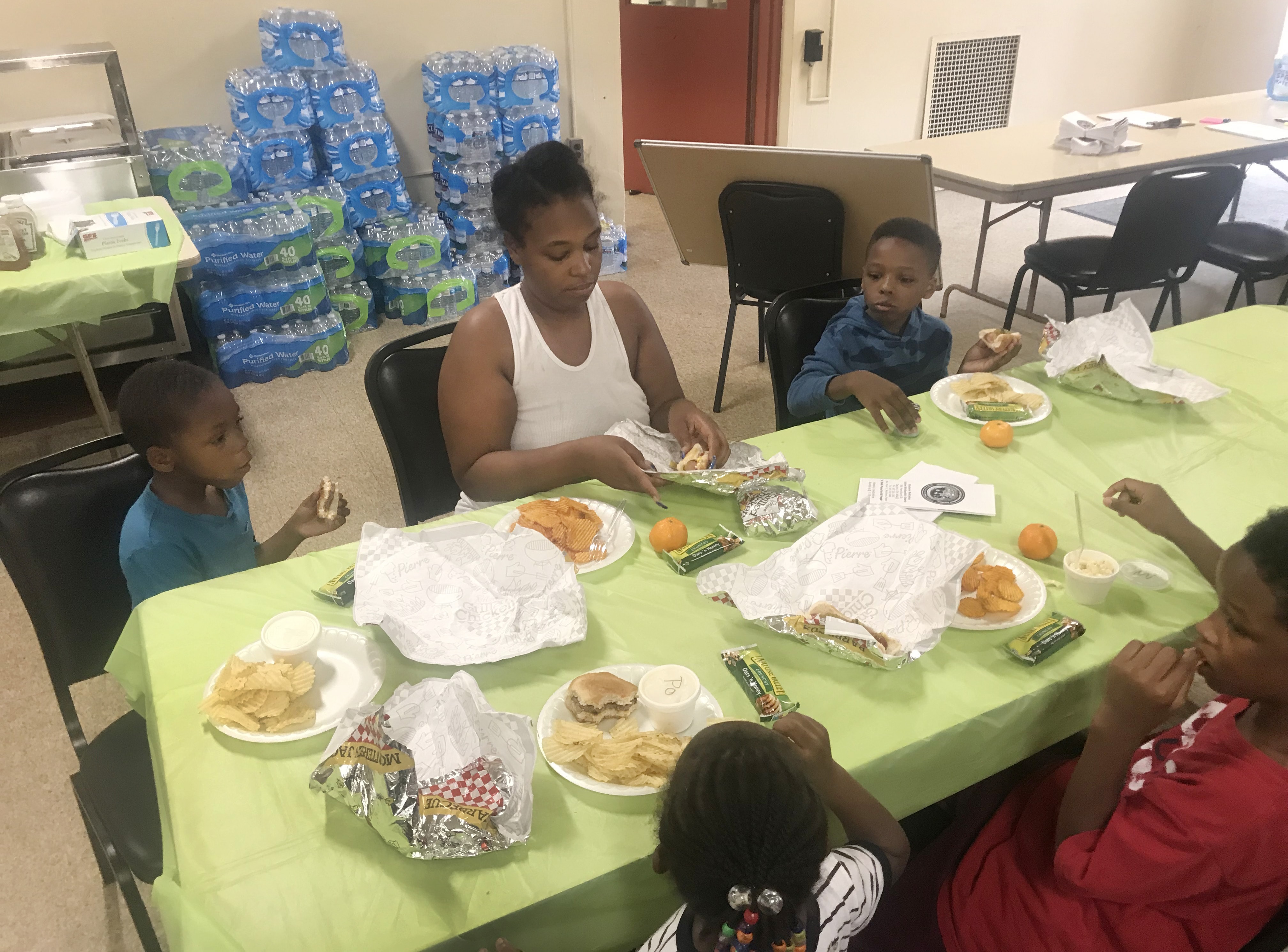 An unidentified woman eats with her children at McKinley United Methodist Church in Dayton, Ohio. The church offered shelter, hot food, free Wi-Fi, cases of water, electricity and clothes. Photo by the Rev. Peter Edward Matthews.