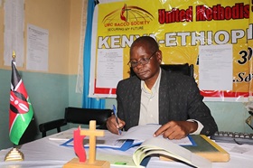 Felix Wandera handles paperwork at the United Methodist Church Savings and Credit Co-Operative Society in Nairobi, Kenya. Wandera is assistant president of the credit union, the first church-based financial institution in the East Africa Episcopal Area. Photo by Gad Maiga, UM News.