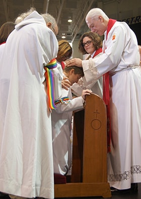 Bishop Thomas J. Bickerton (right) ordains the Rev. Lea Matthews as a deacon in full connection during the New York Annual Conference meeting. Also pictured, from right, are the Revs. K Karpen, Denise Smartt Sears and Heather Sinclair. Photo by Stephanie Parsons, NYAC.