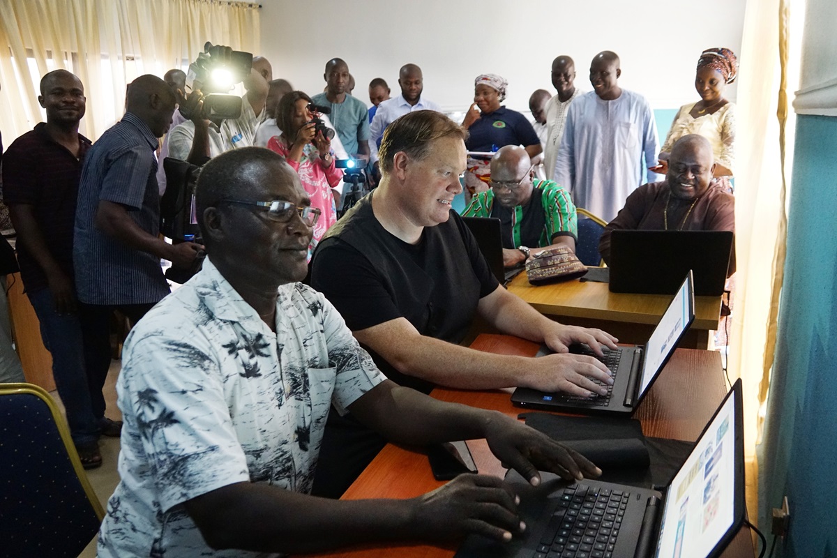 The Rev. John Pena Auta (foreground), provost of Banyan Theological Seminary, works on a computer in the new communications center in Jalingo, Nigeria. Seated next to him is Dan Krause, top staff executive of United Methodist Communications in Nashville, Tenn. In the background are Tafadzwa Mudambanuki (left) from United Methodist Communications and Bishop John Wesley Yohanna of the Nigeria Episcopal Area. Photo by Danny Mai, United Methodist Communications.