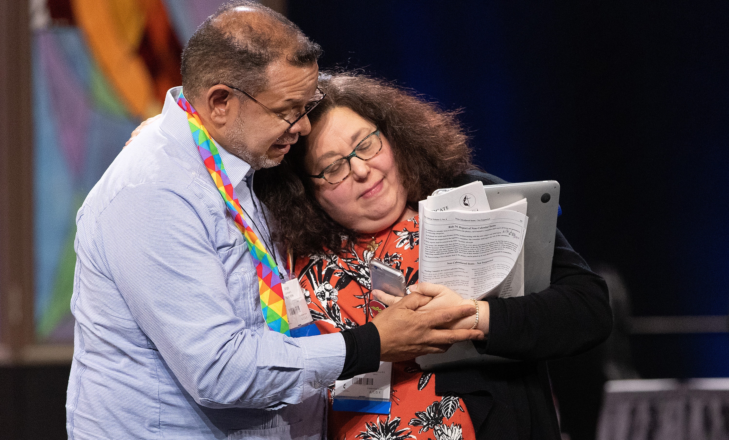 Delegates Jorge Lockward and the Rev. Beth Ann Cook embrace during the closing moments of the 2019 United Methodist General Conference in St. Louis. The two had previously spoken on opposite sides in a debate over possible church exit plans. U.S. conferences are calculating how much a church must pay if it leaves under legislation General Conference approved. File photo by Mike DuBose, UM News.