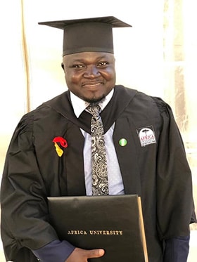 Vincent Yohanna proudly holds his diploma after graduating from Africa University. Photo courtesy of Africa University.
