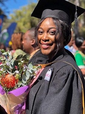 Annie Marie Shamiso Chikati clutches a bouquet during her graduation from Africa University. Photo courtesy of Africa University.