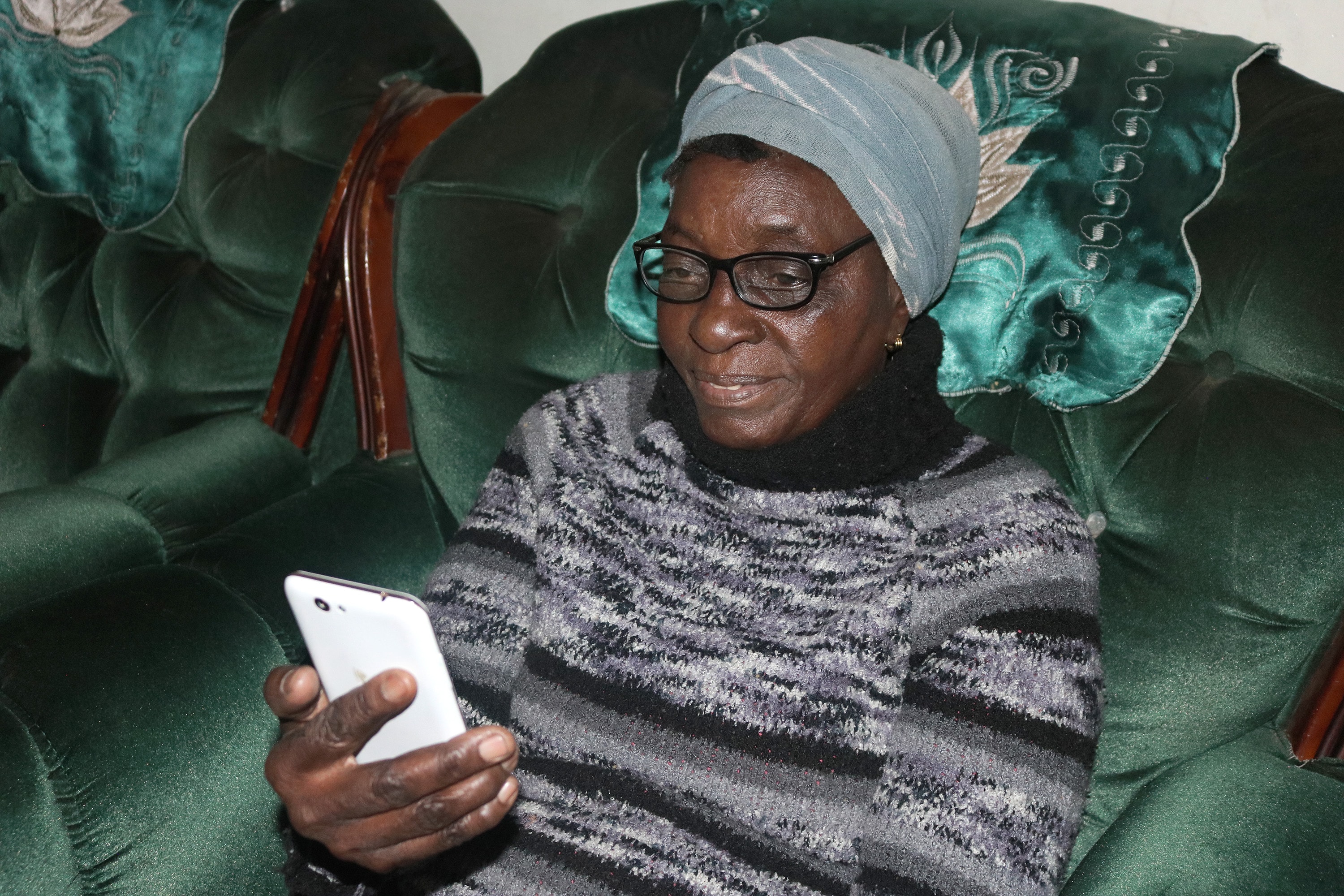 Dorcas Muranda enjoys watching sermons via Facebook on her phone. Churches in Zimbabwe are embracing social media for its ability to bring the Gospel to a larger audience. Photo by Priscilla Muzerengwa, UM News.