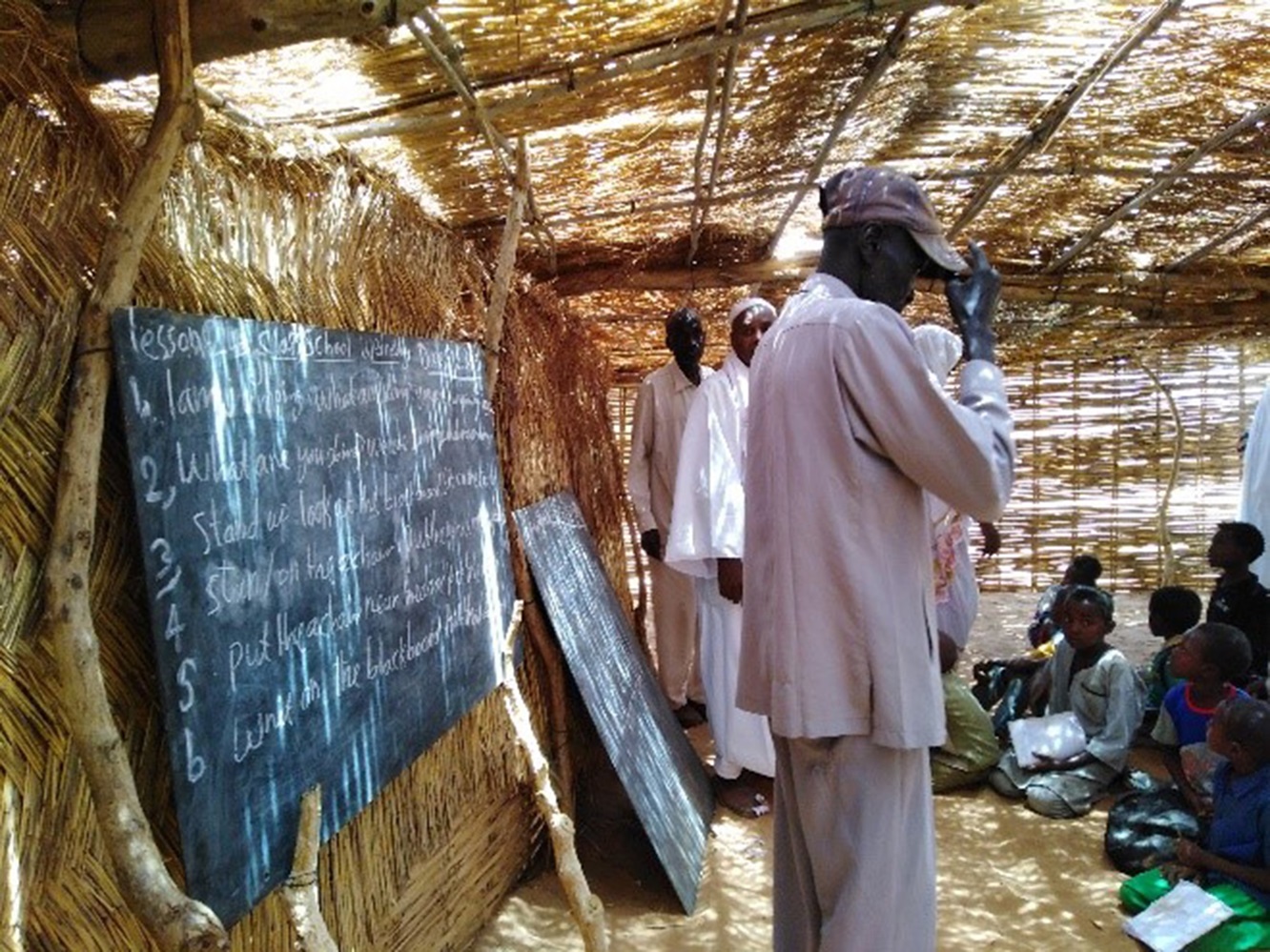 Esta foto de instructores y estudiantes de la actual escuela temporal del campamento de refugiados de Al Nimir, en el estado de Darfur Oriental, demuestra por qué se necesitan más aulas permanentes. Foto por Elrayah, GBGM. 