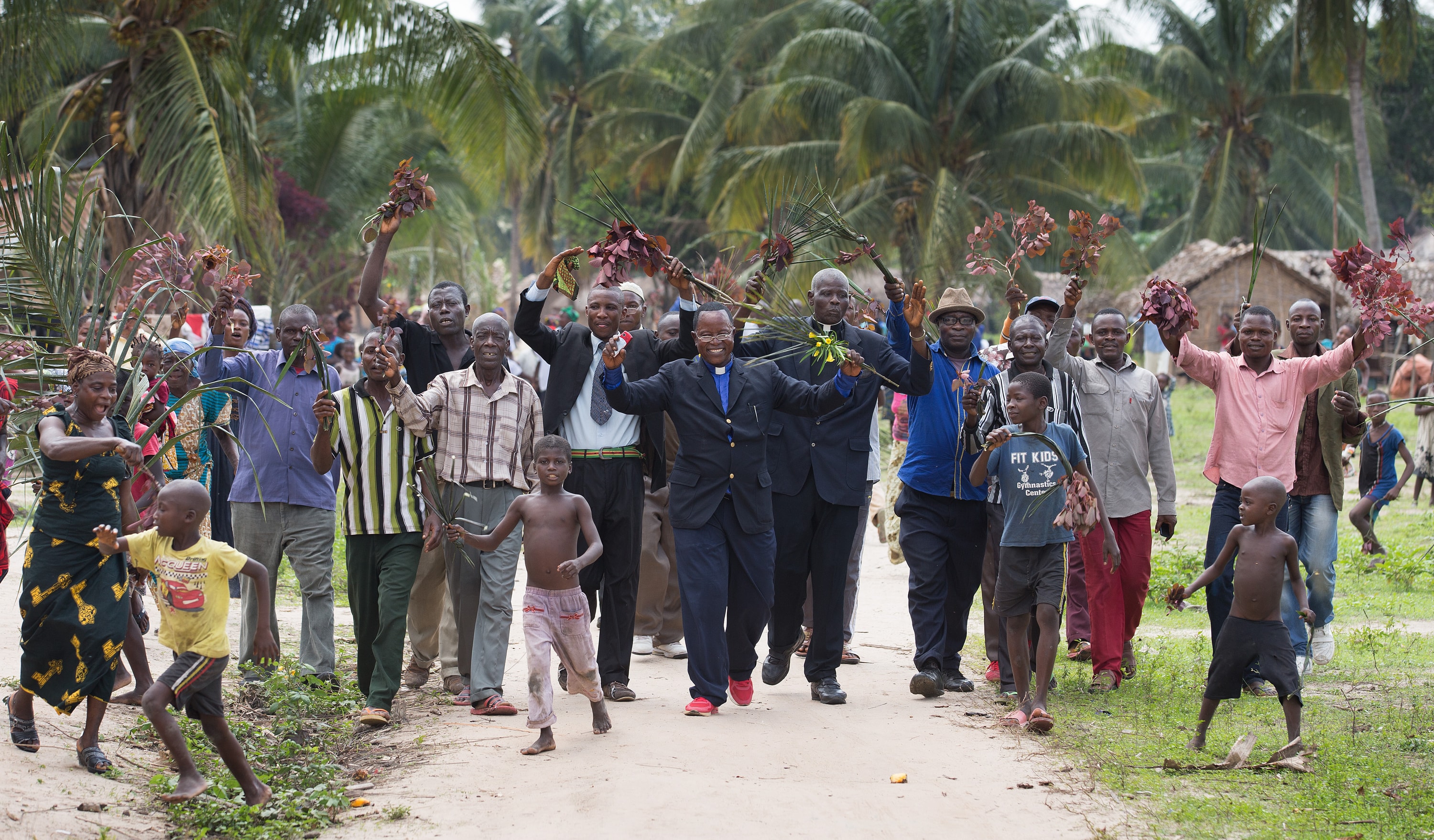 The Rev. Nyenda Okoko (center), a district superintendent, leads a procession of church members as they welcome visitors to Oye United Methodist Church, south of Kindu, Congo, in October 2015. Providing exact membership numbers is difficult in a denomination that spans multiple countries, languages and cultural understandings of church membership. File photo by Mike DuBose, UM News.