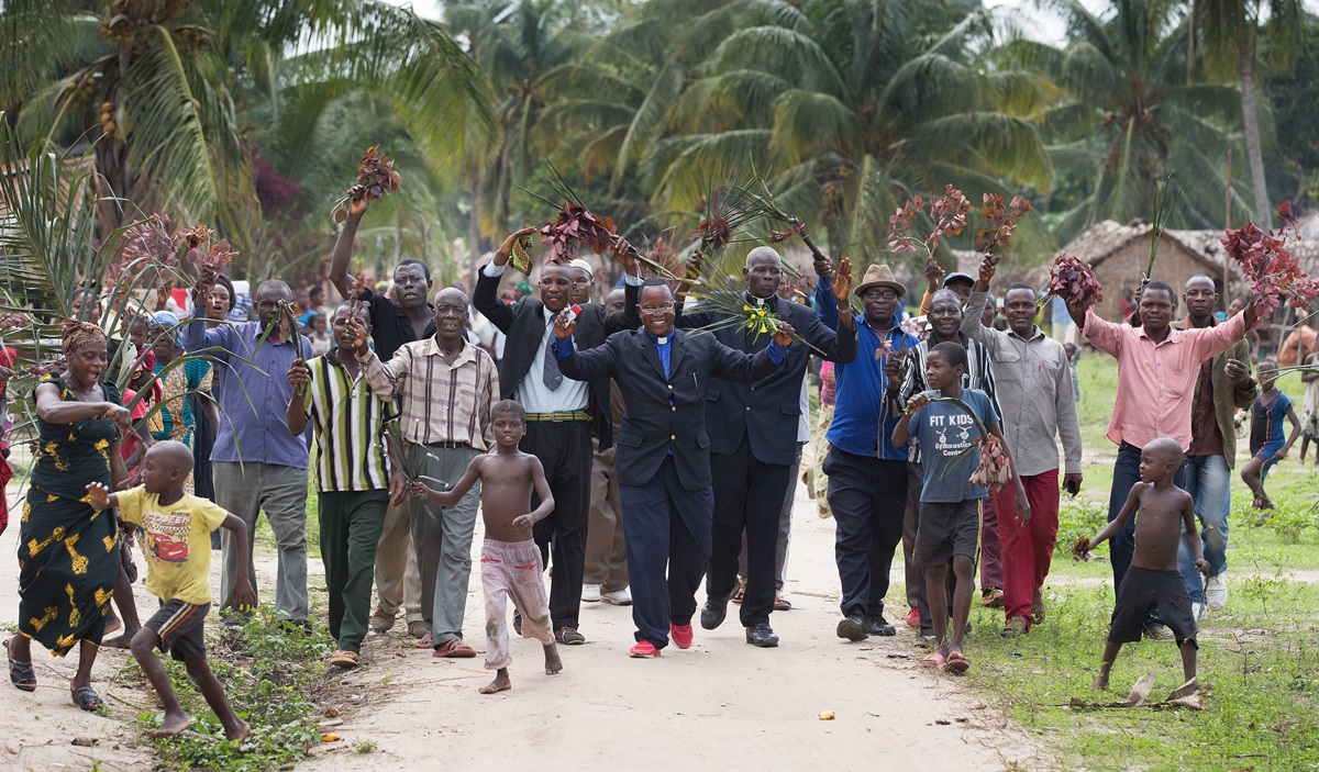 The Rev. Nyenda Okoko (center), a district superintendent, leads a procession of church members as they welcome visitors to Oye United Methodist Church, south of Kindu, Congo, in October 2015. Providing exact membership numbers is difficult in a denomination that spans multiple countries, languages and cultural understandings of church membership. File photo by Mike DuBose, UM News.