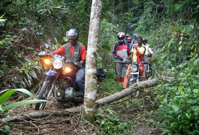 Motorcyclists carrying a United Methodist delegation make their way around a fallen tree near Tunda, Congo, in October 2015. Road conditions routinely make for difficult travel in Congo. File photo by Mike DuBose, UM News.