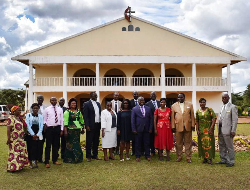 The Zimbabwe Episcopal delegation stand in front of Joli Site Church in Galilee during their visit in the South Congo Episcopal Area. Photo by Chenayi Kumuterera, UM News. 
