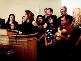 Francisca Lino, who is living in sanctuary at Adalberto United Methodist Church in Chicago, stands with her family and Democratic politicians as well as the Rev. Emma Lozano, pastor of Lincoln United Methodist (far right) during a news conference at the church. Lino is a mother of five U.S. citizen children, wife of a U.S. citizen and has four U.S. citizen grandchildren. Photo by Sara Walker, Lincoln United Methodist Church.