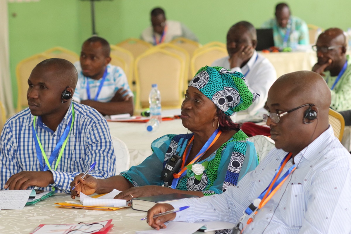 International participants listen during a presentation at the United Methodist HIV/AIDS summit in Abidjan, Côte d’Ivoire. From left are Augustin Bahati, communicator and member of the Rwanda Provisional Conference’s health board;  Pauline Roberts, HIV and AIDS counselor and coordinator for the Liberia Conference; and Dr. Madaki Micah Musa, chairman of the church’s health board in the Nigeria Conference. Photo by Isaac Broune, UMNS.