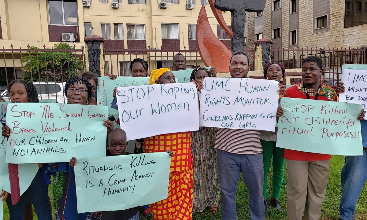 Protesters hold placards protesting violence against women and children. They are standing outside The United Methodist Church Central Office in Monrovia, Liberia. Photo by E Julu Swen, UM News. 
