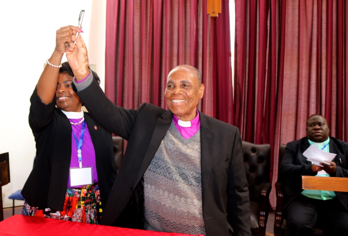 Bishops Cynthia Moore-Koikoi (left) of the Western Pennsylvania Conference and Eben K. Nhiwatiwa of the Zimbabwe Area celebrate the signing of a continuing partnership covenant between the two areas during the 2019 Laity Academy at Africa University in Mutare, Zimbabwe. Photo by Eveline Chikwanah, UM News.