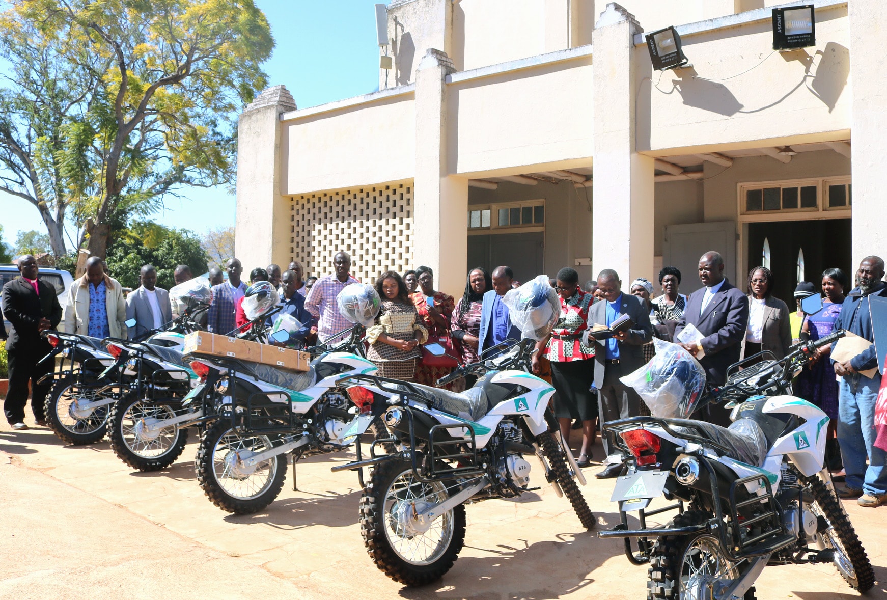 The ministry of five pastors was transformed when they were given motorbikes at a ceremony at Old Mutare Circuit in the Mutasa Nyanga District of Zimbabwe on July 20. The harsh topography makes most of the area inaccessible by traditional motor vehicles. Officiating was the Rev. Alan Masimba Gurupira, administrative assistant to Bishop Eben K. Nhiwatiwa, Zimbabwe Episcopal Area (center right, reading). Photo by Kudzai Chingwe, UM News.