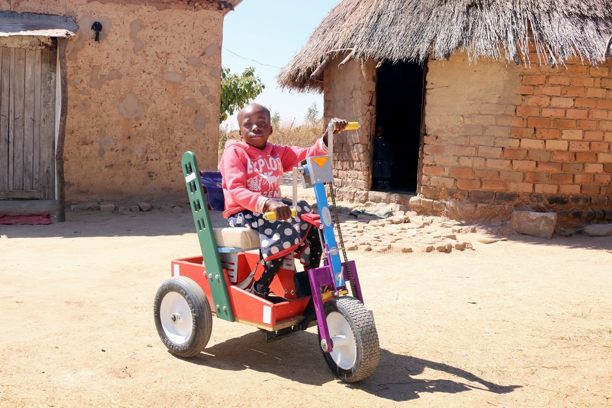 Portia Kasuso, 11, experimenta sua nova cadeira de rodas com pedal manual durante um serviço de reavivamento dos Metodistas Unidos em Murewa, no Zimbábue. O presente da cadeira de rodas foi facilitado pela Conferência Oeste da Igreja no Zimbábue. Foto do Rev. Taurai Emmanuel Maforo, Notícias MU. 