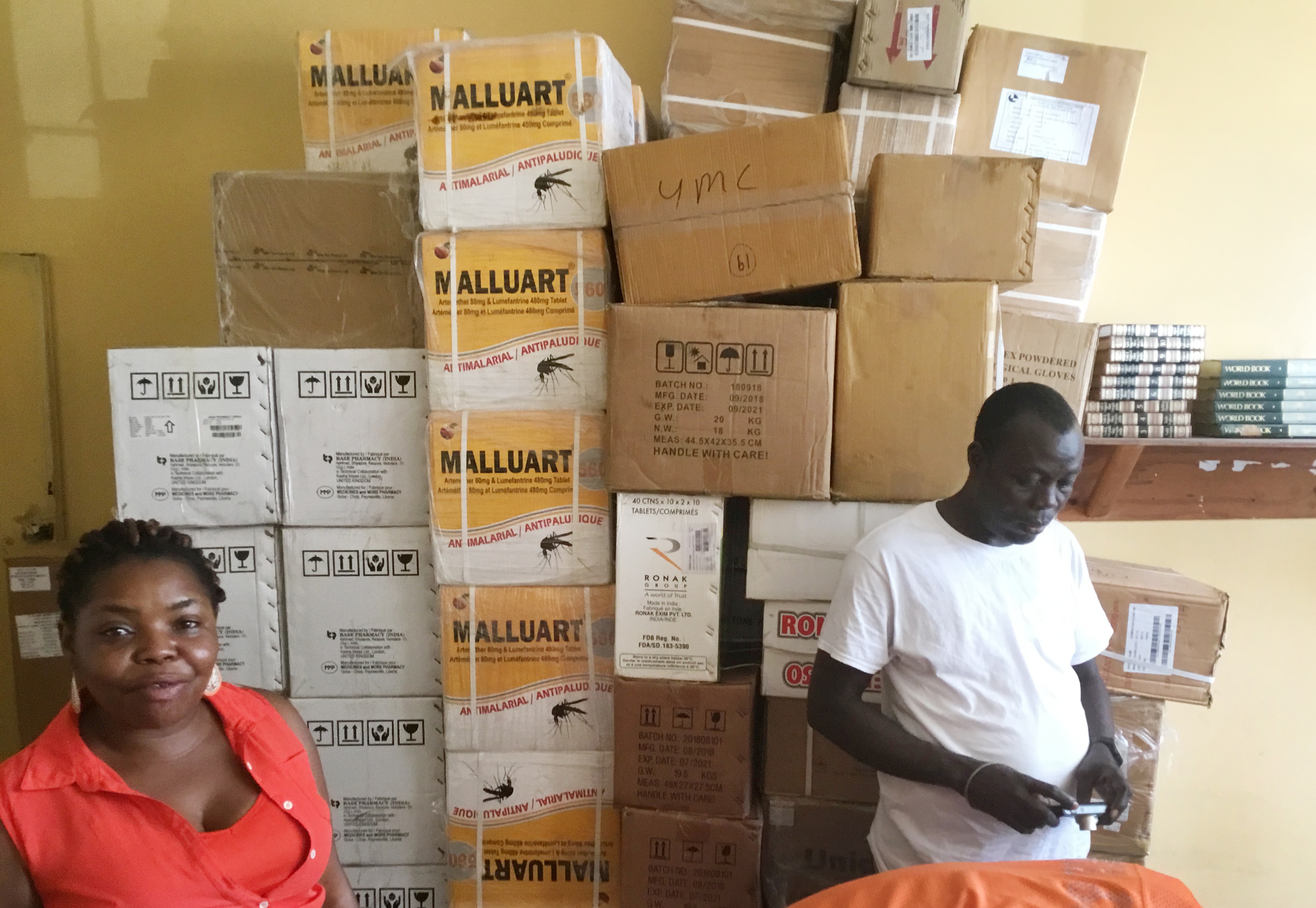 Laurine Deemi and Thomas Mallah stand in front of medical supplies at The United Methodist Church in Liberia’s health department in Monrovia, Liberia. The United Methodist Board of Global Ministries has donated over $40,000 worth of anti-malarial medicine, tests and mosquito nets to the church in Liberia. Photo by E Julu Swen, UM News.