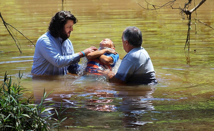 The Rev. Jarrod Caltrider (left) is a young United Methodist elder who serves three West Virginia churches, and he sometimes does creek baptisms. A new study of clergy age trends in the denomination shows the number of U.S. elders under age 35 is near a historic low. Photo courtesy of Jarrod Caltrider.