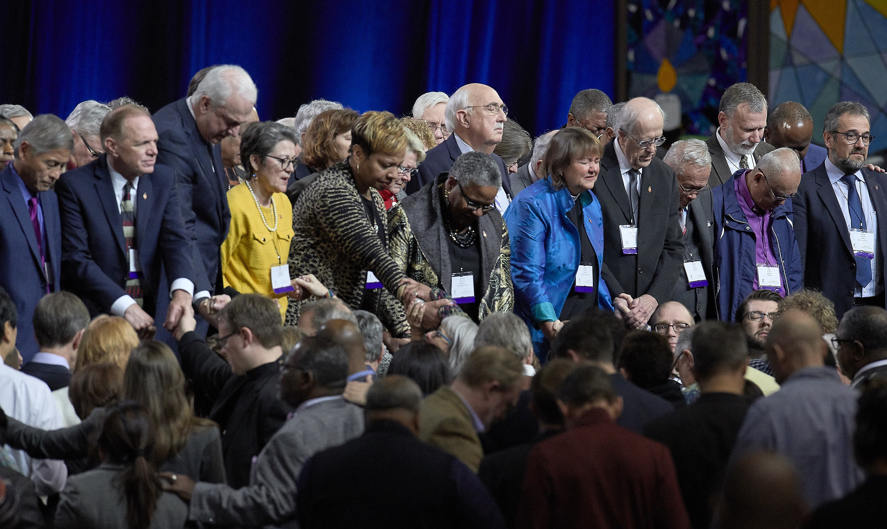 2월 26일 세인트루이스에서 열린 연합감리교회 특별총회에서 동성애에 관한 교회 정책의 주요 투표를 앞두고 연합감리교 감독들과 대의원들이 무대 앞에서 기도하고 있다. 사진, 폴 제프리, 연합감리교뉴스.