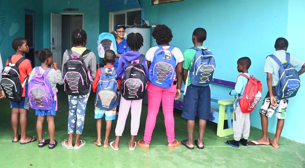 Rotary Club president Susan Culmer presents backpacks to students in a shelter for Hurricane Dorian evacuees at Bahamas Methodist Habitat on Eleuthera Island. The backpacks were donated by the local Rotary Club. Photo by Maisie Thomson.