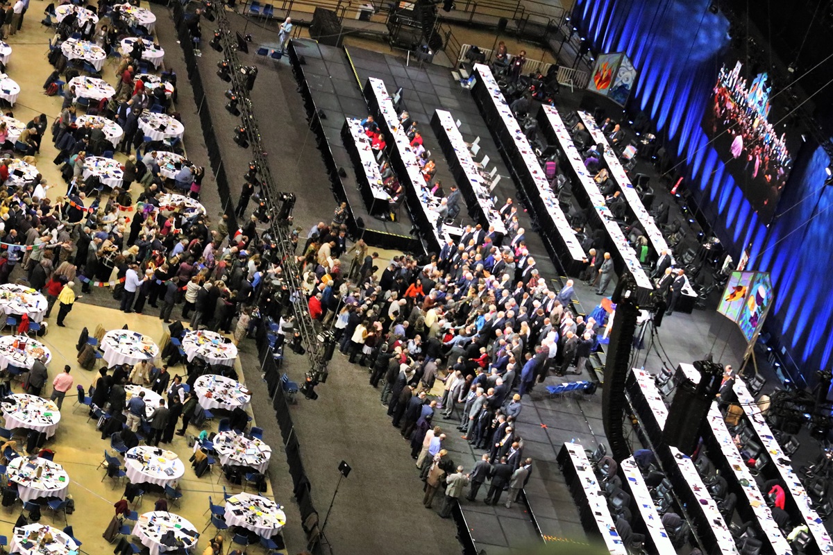 Delegates and bishops join in prayer at the front of the stage before a key vote on church policies about homosexuality during the 2019 United Methodist General Conference in St. Louis. The docket of the Oct. 29-Nov. 1 Judicial Council meeting in Evanston, Illinois, includes items related to decisions made by the denomination in St. Louis. File photo by Thomas Kim, UM News.