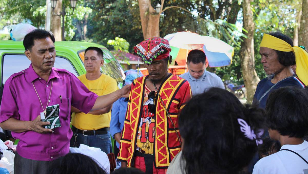 Bishop Rodolfo A. Juan (left) prays for a leader (red vest) at a camp for displaced people in Malaybalay, Philippines, in 2017. The United Methodist Church in the Philippines has condemned extrajudicial killings and other human rights abuses in the country, as well as protesting the treatment of indigenous people. The church has worked both alone and through ecumenical groups like the National Council of Churches. File photo courtesy of Dan Ela.