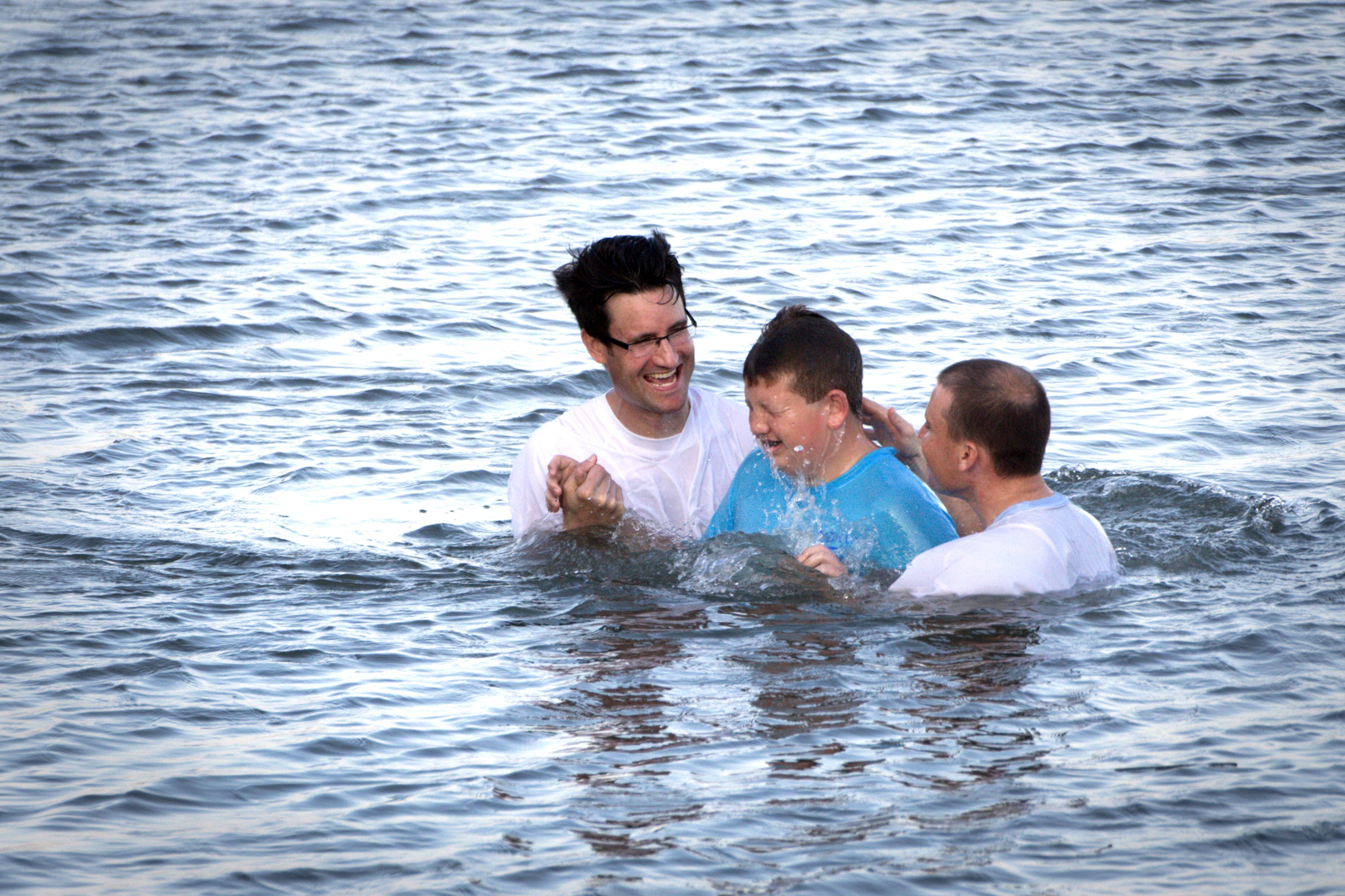 Marshall Greene (center) is baptized during the Annual Inlet Baptism in Murrells Inlet off the Belin Memorial United Methodist Church's seawall. Holding him is (left) Austin Bond, director of youth ministries and (right) Walter Cantwell, associate pastor. Photo by Benjamin Coy.