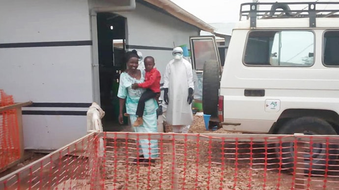 Six-year-old David Usumbu is carried by his mother, Masika Bahati Nehema, after being discharged from a transit center in Beni, Congo, where he was being monitored after showing symptoms of Ebola. He did not have the virus, but the Ulangi family has faced difficulty integrating back into the community. Photo courtesy of the Ulangi family.