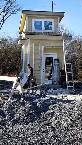 Carpenters work on details of one of the micro houses. Photo by Kathleen Barry, UM News. 