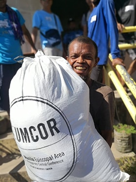 An earthquake survivor in the Nabuklod community in Floridablanca, Philippines, shares a smile after receiving food distributed by The United Methodist Church in the Philippines and funded by the United Methodist Committee on Relief. Photo by the Rev. Gilbert Cedillo.