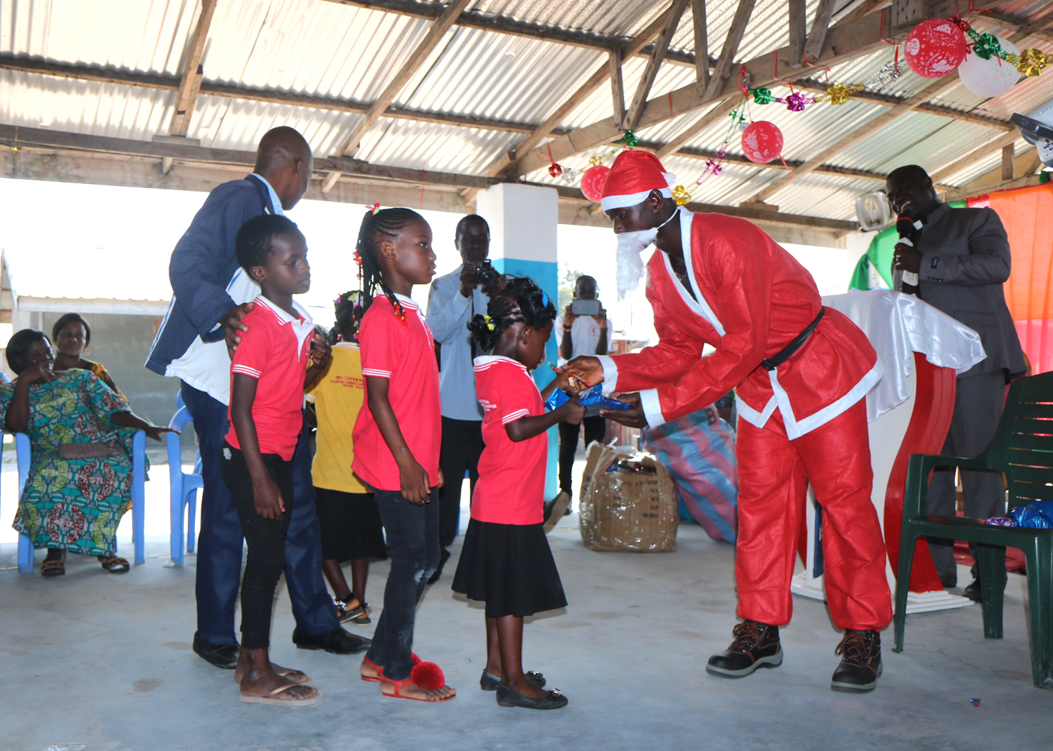 Children line up to receive a gift from Santa at Ampain Ivorian Refugee Camp in southwestern Ghana on Christmas Day. The Aboisso District of The United Methodist Church in Côte d’Ivoire organized the celebration and gifts for more than 540 children. Photo by Isaac Broune, UM News.