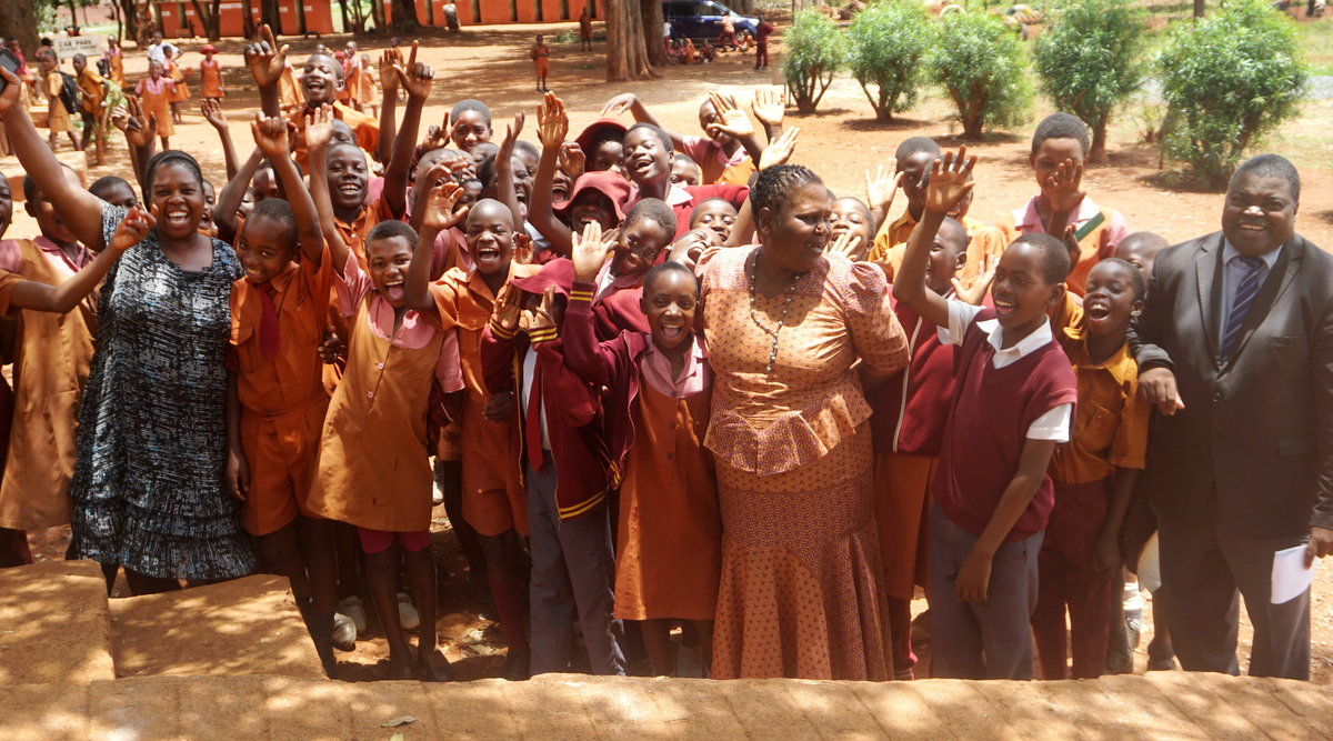 Elasto Musakanda (right), headmaster at Pagejo Rarubi Primary School, shares a laugh with students and staff at Pagejo Rarubi Farm in rural Zimbabwe. The United Methodist church established on the property has been paying school fees for 20 pupils annually and providing supplies and other support, he said. Photo by Kudzai Chingwe, UM News.