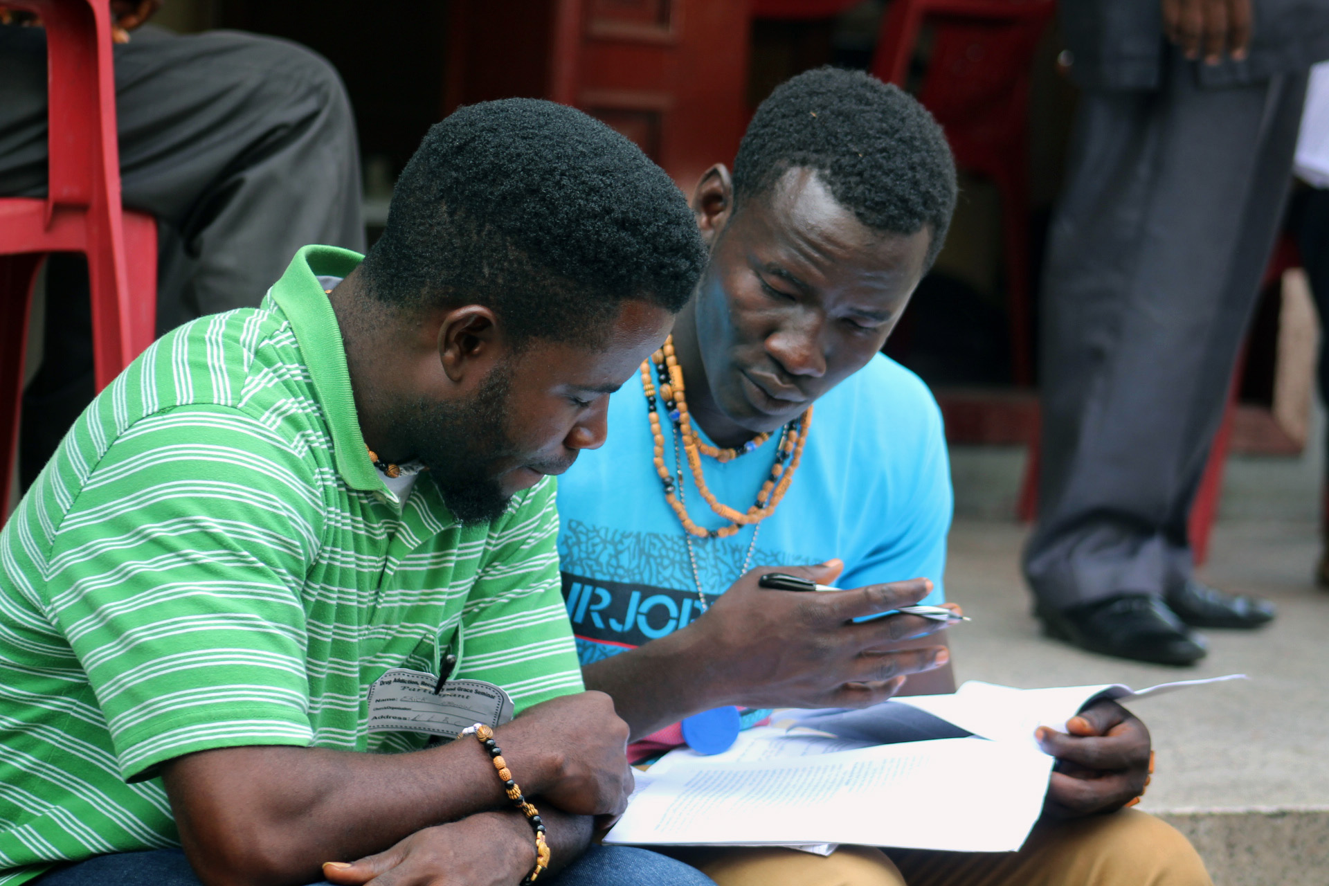 Eric Nyenow (left) and Emmanuel Gbuie, residents of the United Methodist New Life Recovery Center, review their notes during an addiction and substance abuse seminar in Monrovia, Liberia. The United Methodist Church in Liberia hosted the seminar to help local churches expand and strengthen their recovery ministries. Photo by E Julu Swen, UM News.