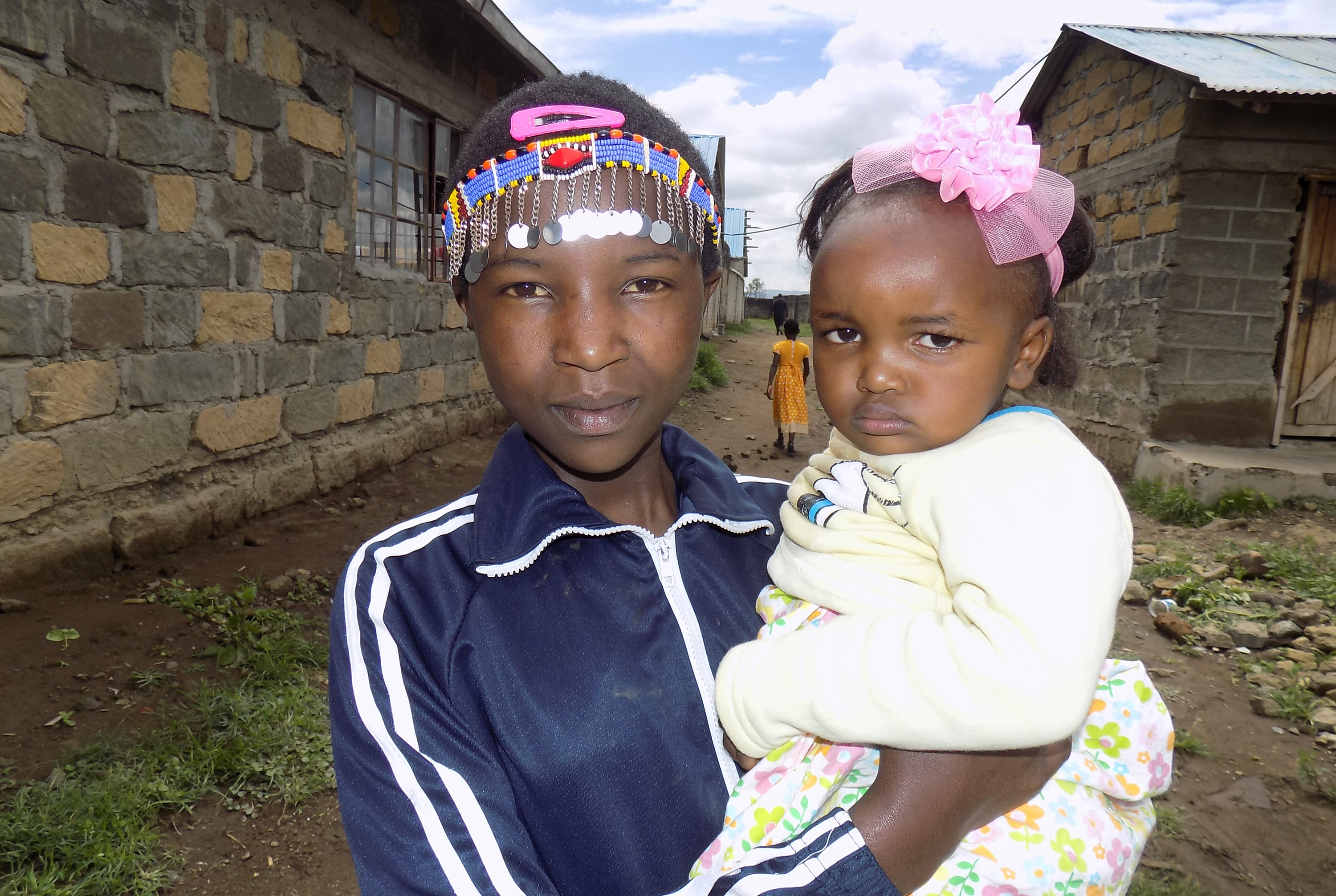 Jecinta Nairesea, 12, holds her 2-year-old daughter, Dorcus Nchorira, outside Trinity United Methodist Church in Gilgil, Kenya. The young mother was among those who attended the church’s youth camp in December. Jecinta, who was forced to marry at age 9, now attends Trinity Mission Girls High School. Photo by Faith Wanjiru, UM News.