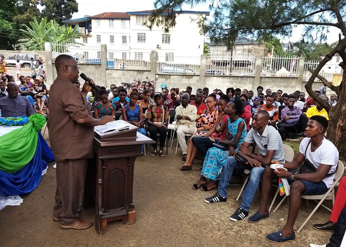 Professor George Carew addresses students during orientation at the United Methodist University Preparatory Program campus in Brookfields, Sierra Leone, in western Freetown. The new program prepares students to retake their high school exit exams. Over 95% of Sierra Leonean students who took the 2019 West African Senior School Certificate Examinations failed to score high enough to meet university requirements. Photo by Phileas Jusu, UM News.