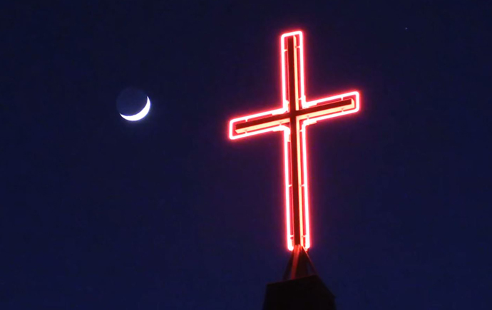 A neon cross atop Celebration United Methodist Church illuminates the night sky in Brandon, South Dakota. The pastor of the church, the Rev. Jason Martens, says the importance of frequent and frank communication can’t be overstated in a church restart. Photo courtesy of the Rev. Jason Martens, Celebration United Methodist Church.