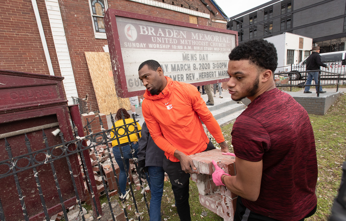 Gerald McRath (left) and Christian Hooper join with other volunteers to clear tornado debris outside Braden Memorial United Methodist Church in Nashville, Tenn. Both are members of the church. McRath played for the Tennessee Titans NFL team from 2009-2012. Photo by Mike DuBose, UM News.