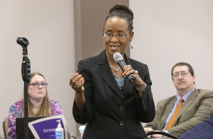 The Rev. Kennetha J. Bigham-Tsai speaks during the meeting of the General Council of Finance and Administration board. Listening in the background are Sara Hotchkiss and the Rev. Gary Graves. Photo by Kathleen Barry, UM News.