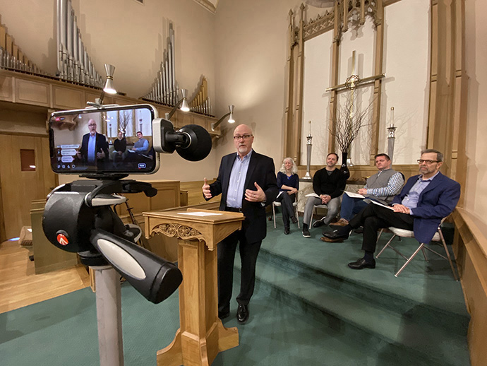 The Rev. Eric Folkerth, senior pastor of Kessler Park United Methodist Church in Dallas is recorded with a cell phone during a service March 15. The church is livestreaming their services on Facebook due to the coronavirus or COVID0-19. Photo by Brett Shipp, courtesy of Kessler Park United Methodist Church.