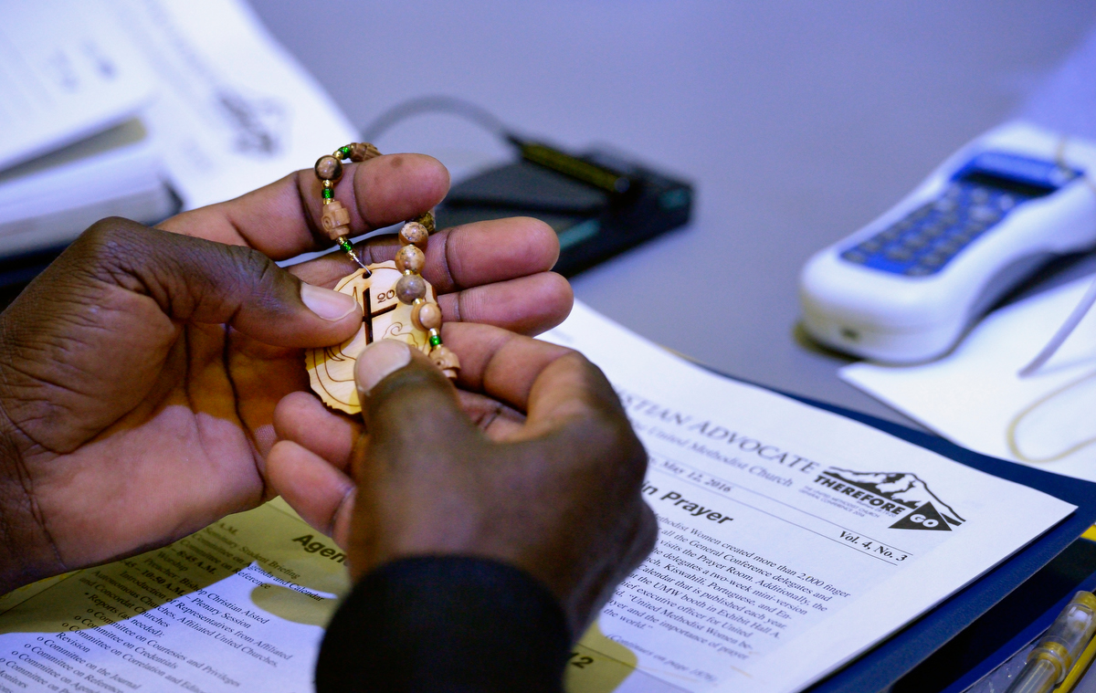 A delegate handles prayer beads during prayer at the 2016 United Methodist General Conference in Portland, Ore. With the coronavirus delaying the 2020 General Conference, church leaders hope United Methodists can experience more time to pray and be the church. File photo by Paul Jeffrey, UM News.