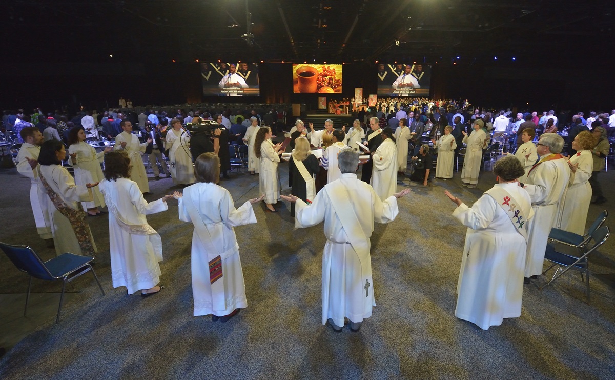 Clergy members bless the elements of Holy Communion during the 2016 United Methodist General Conference in Portland, Ore. The Commission on the General Conference met March 21 to discuss next steps after coronavirus concerns forced the postponement of this year’s legislative assembly. File photo by Paul Jeffrey, UM News.
