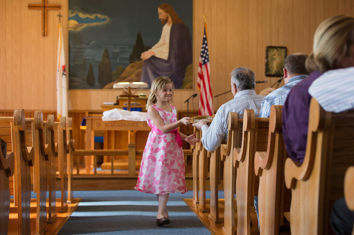 Elizabeth Knotts collects the offering at New Hope Valley United Methodist Church in Valley Furnace, W.Va., in 2015. Churches are dealing with tight finances in this time of suspended worship and shuttered businesses because of COVID-19. Still, giving continues. File photo by Mike DuBose, UM News.