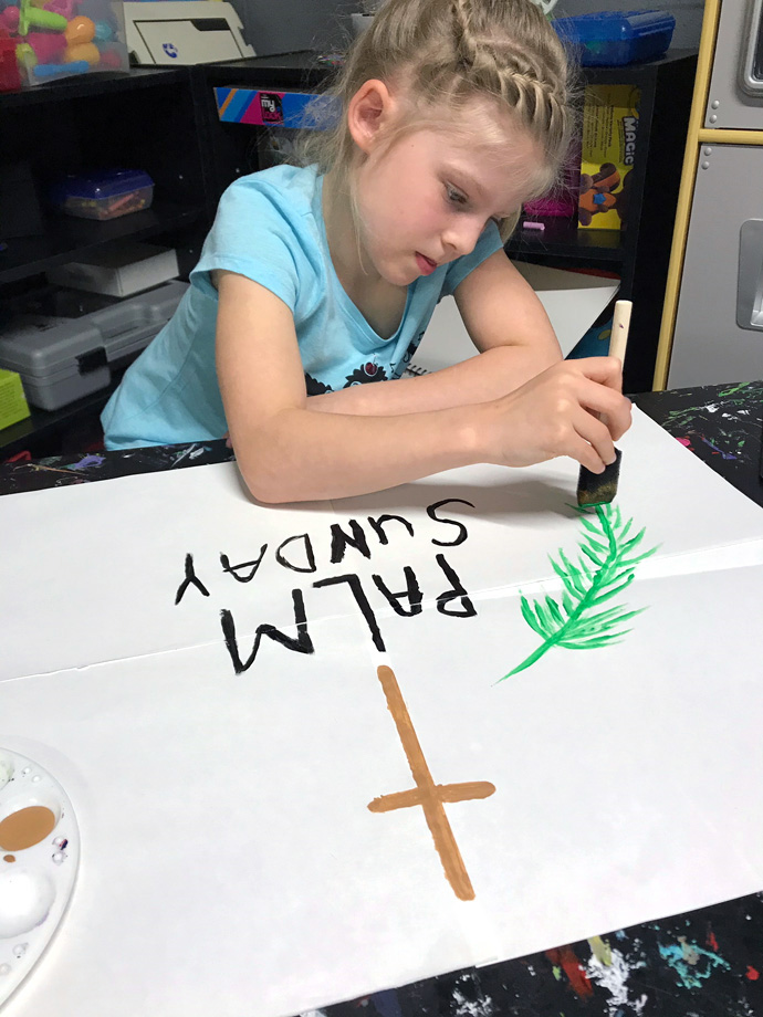 Zoey Rosenbaum, 8, works at home on a Palm Sunday banner. Her church, Trinity United Methodist in Clearfield, Pa., is worshipping online because of the coronavirus threat but hopes to have members drive around town on Palm Sunday afternoon, displaying signs that proclaim the day. Photo courtesy of Trinity United Methodist. 