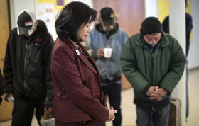 The Rev. Elizabeth McVicker, pastor of First United Methodist Church in Salt Lake City, visits and prays with the homeless during the Sunday Fellowship Breakfast. Photo by Kathleen Barry, UM News.