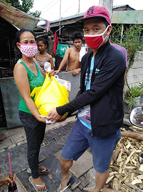 Louie David (right), United Methodist Young Adults vice president, delivers food relief to families in the Balete barangay, inside Hacienda Luisita in Tarlac City, Philippines. Photo courtesy of the Rev. Marlon Magno.