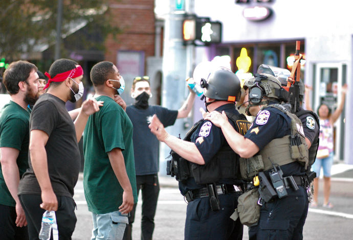 Men talk with police in downtown Louisville, Kentucky, during four days of protests May 28-31 over the killings by police of Breonna Taylor in Louisville and other African Americans. One person was killed and seven injured during the protests in Louisville. Photo by Cathy Bruce, courtesy of the Kentucky Conference.