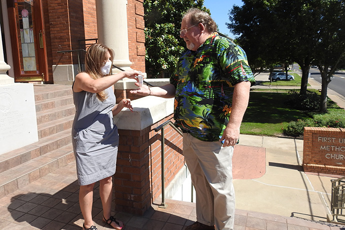 Lisa Lantz applies hand sanitizer for Stephen Morgan before a June 14 worship service at First United Methodist Church of Sulphur Springs, Texas. The church resumed in-person worship that day, taking various safety measures because of the coronavirus pandemic. Photo by Sam Hodges, UM News.