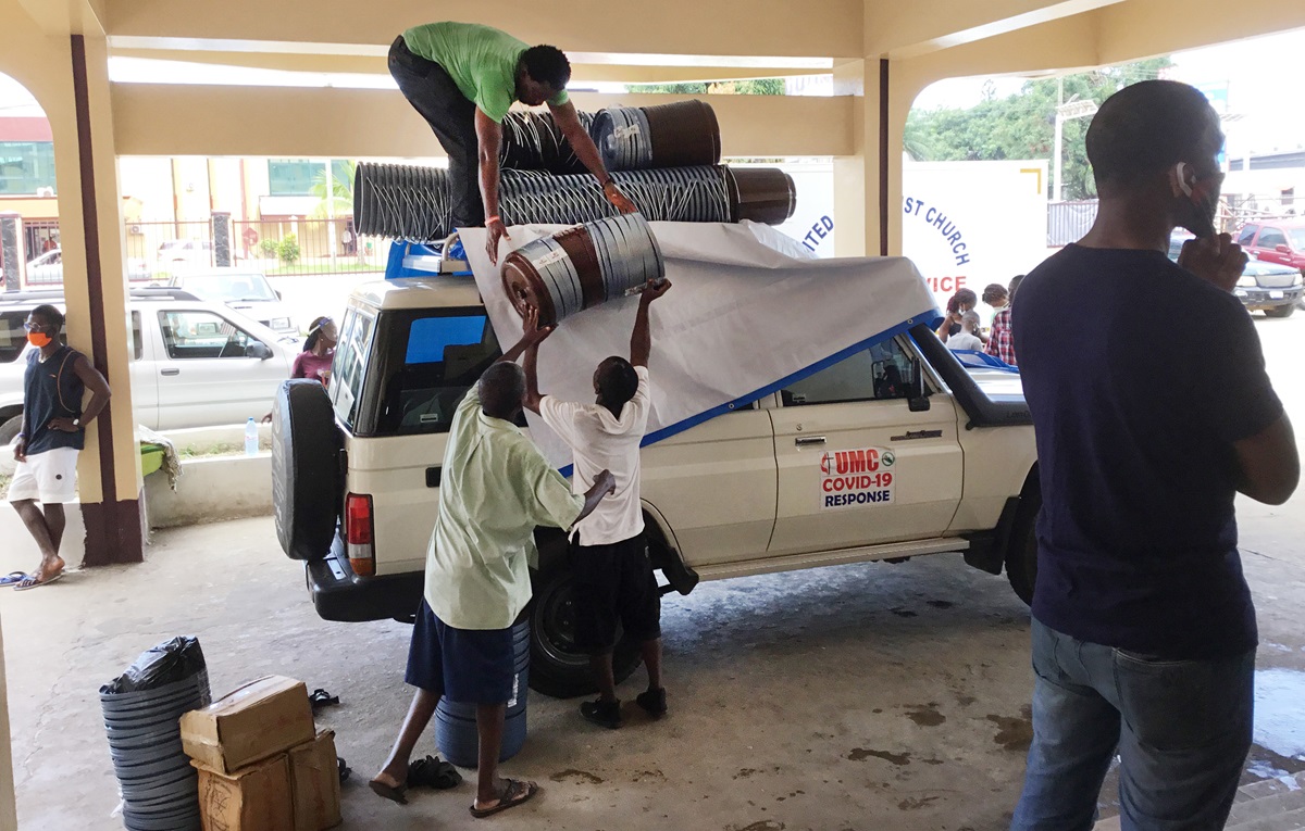 Workers with the church’s Department of Community Services load supplies onto a vehicle to deliver to rural Liberia. The food relief — supported by UMCOR and other global partners — is part of the efforts of The United Methodist Church’s Anti COVID-19 Taskforce. Photo by E Julu Swen, UM News. Workers with the church’s Department of Community Services load supplies onto a vehicle to deliver to rural Liberia. The food relief — supported by UMCOR and other global partners — is part of the efforts of The United Methodist Church’s Anti COVID-19 Taskforce. Photo by E Julu Swen, UM News.