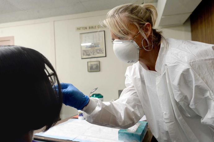 Kellie Ricks (right) of American Family Care performs a COVID-19 test at McCabe-Roberts United Methodist Church in Beaumont, Texas, on June 23. McCabe-Roberts and Trinity United Methodist Church of Beaumont are partners in hosting the site. Photo by Kim Brent, The Beaumont Enterprise.