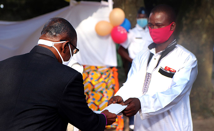 Bishop Benjamin Boni gives an envelope of cash money to Seydou Bakayoko, who lost five relatives in the floods in Abidjan. Each bereaved family received $100 for each person who died during a special ceremony held in Anyama, Côte d’Ivoire. Photo by Isaac Broune, UM News.